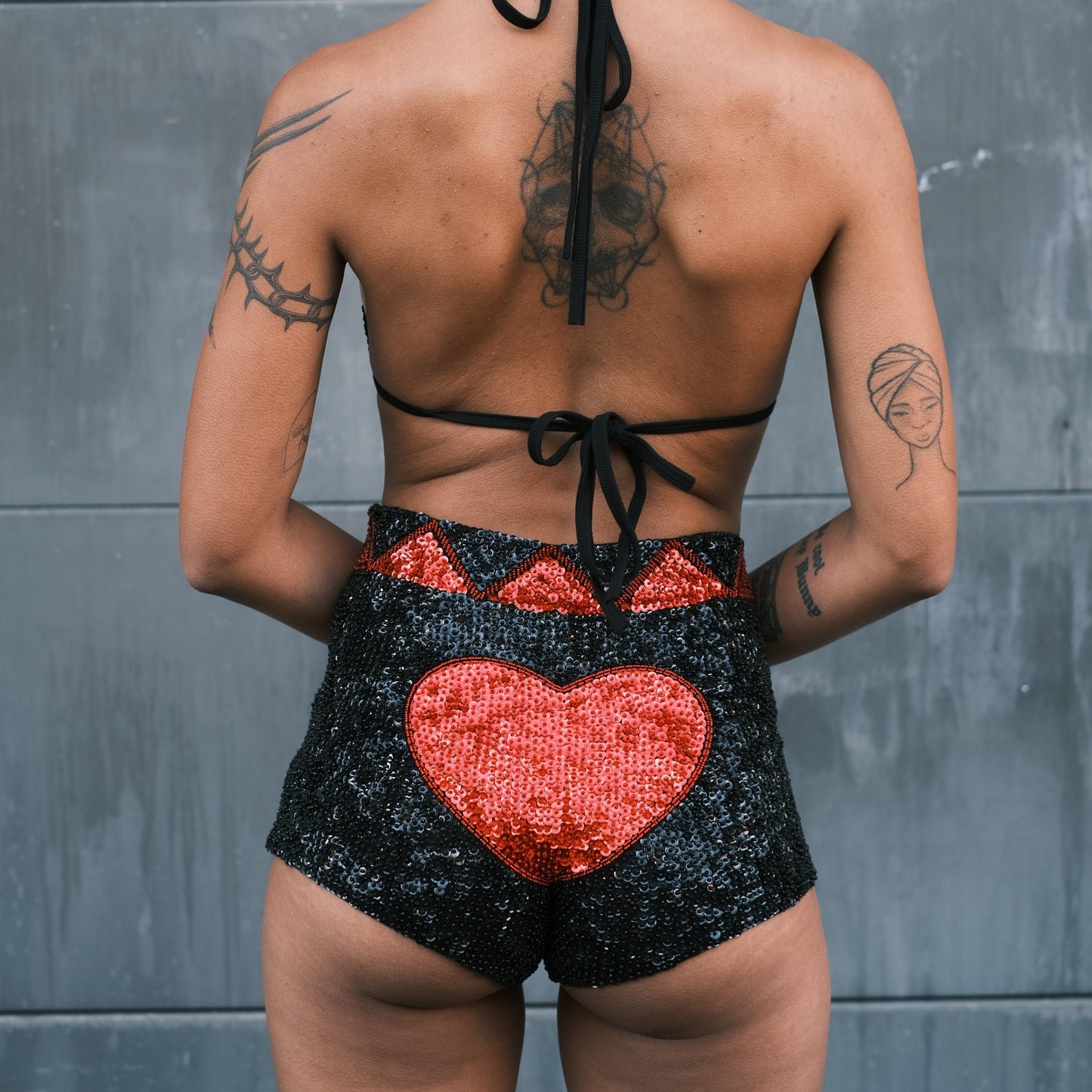 Black and red sequin hot pants with handmade love heart patterns, perfect for festival wear. Matches with crop top for Burning Man and Shambhala festivals.