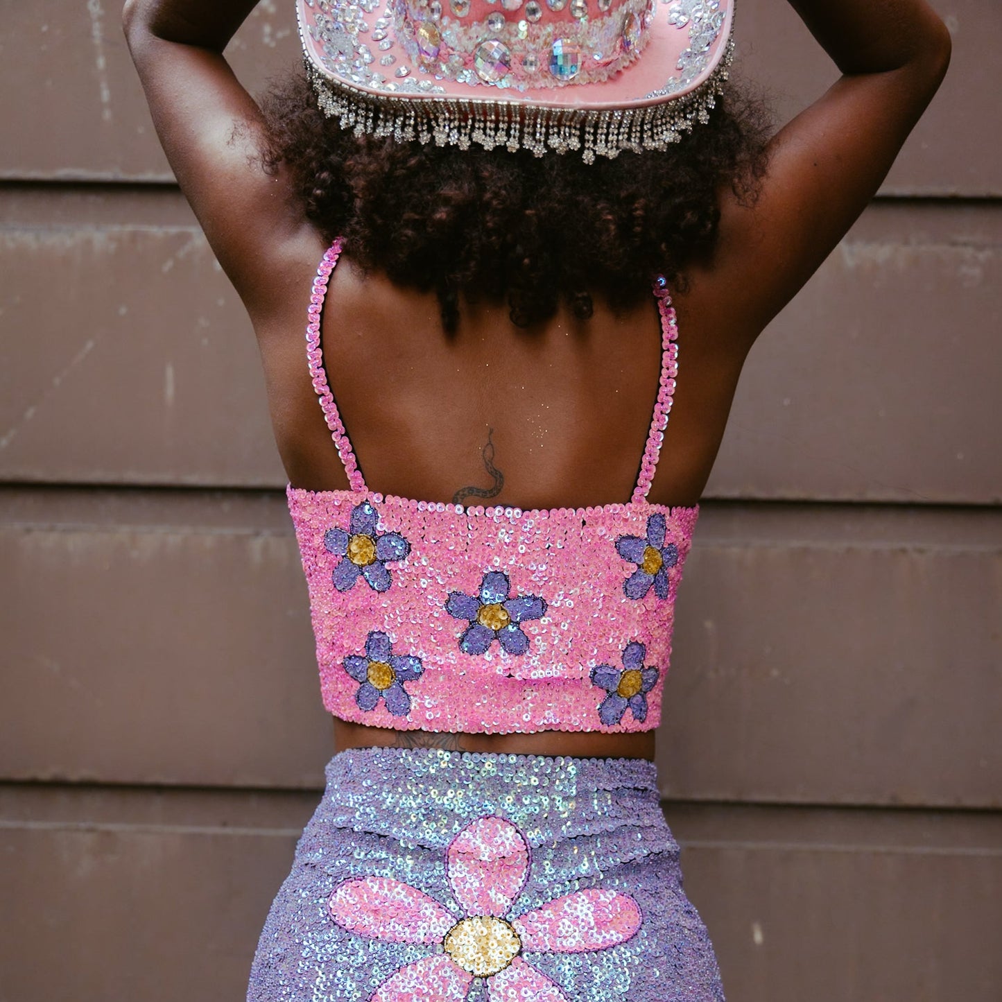 Vibrant pink and purple crop top with floral sequins. Handmade for a stylish festival outfit or Taylor Swift Eras Tour look. Comfortable and eye-catching for a memorable appearance.