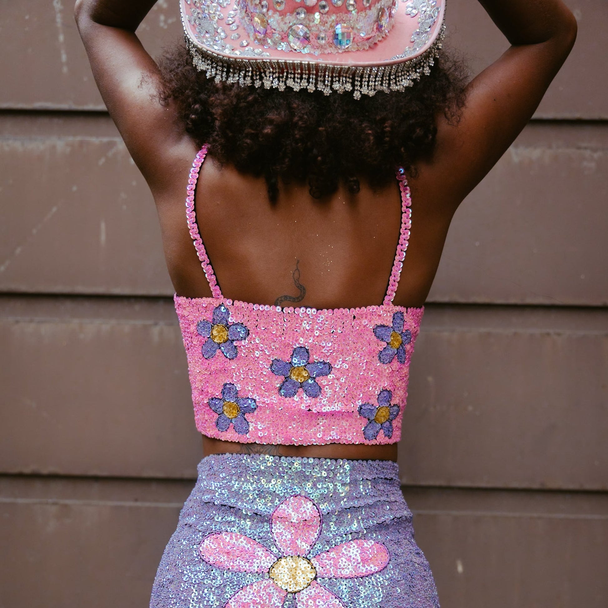Vibrant pink and purple crop top with floral sequins. Handmade for a stylish festival outfit or Taylor Swift Eras Tour look. Comfortable and eye-catching for a memorable appearance.