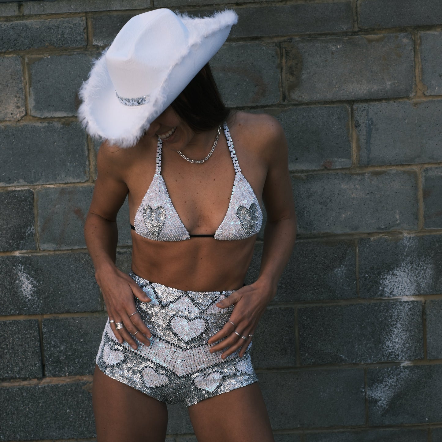 Handmade bikini top adorned with holographic silver and pearl white love hearts. The perfect addition to a Taylor Swift Eras Tour Lover outfit or bachelorette festival set.