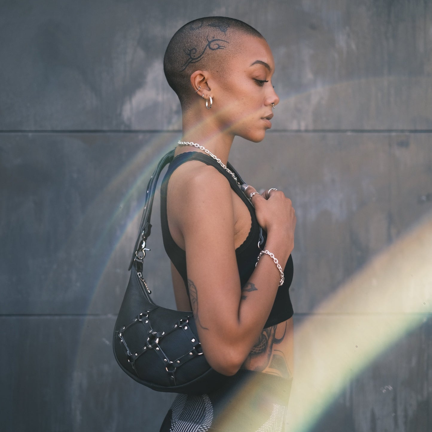 bondage style festival bag made from leather with bold silver hardware and detailing on the front
