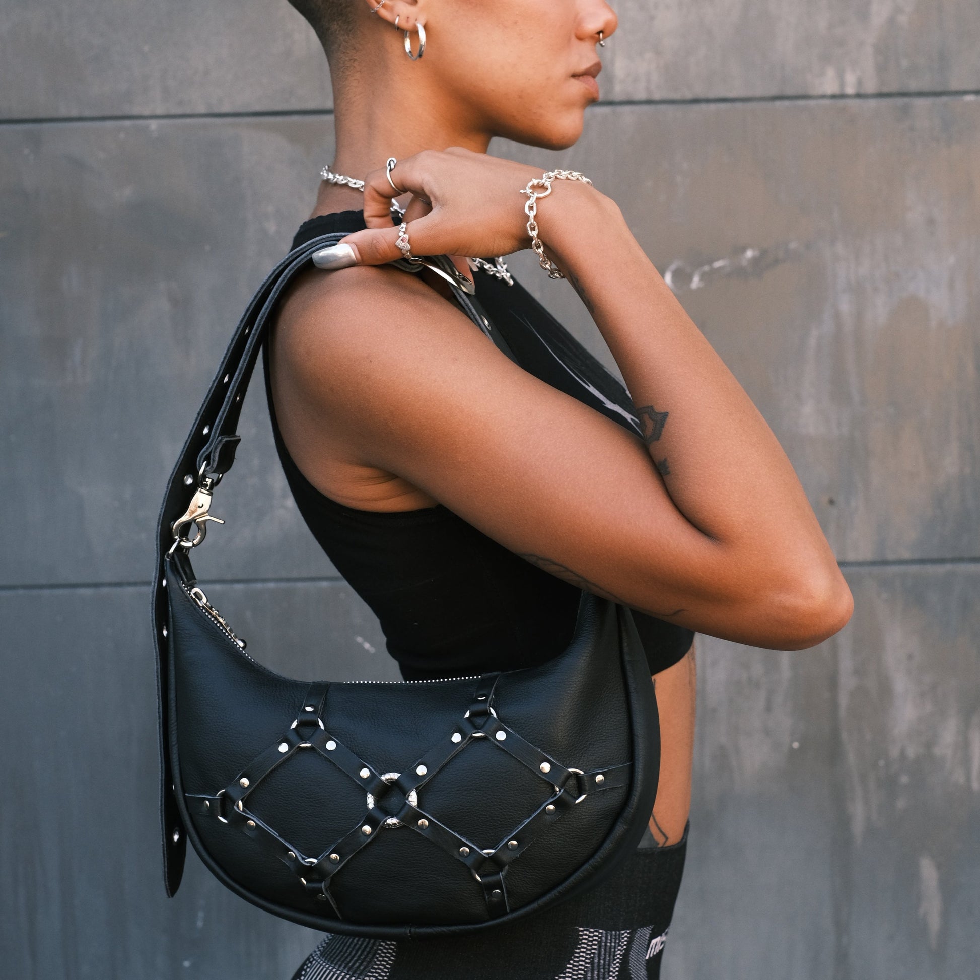 Handmade leather handbag perfect for grunge and alt fashion enthusiasts. Features bold bondage detailing on the front, making it an ideal festival bag for Burning Man with a Mad Max style. Versatile design allows it to be worn cross-body as a bum bag or on the shoulder as a handbag, thanks to its adjustable shoulder strap