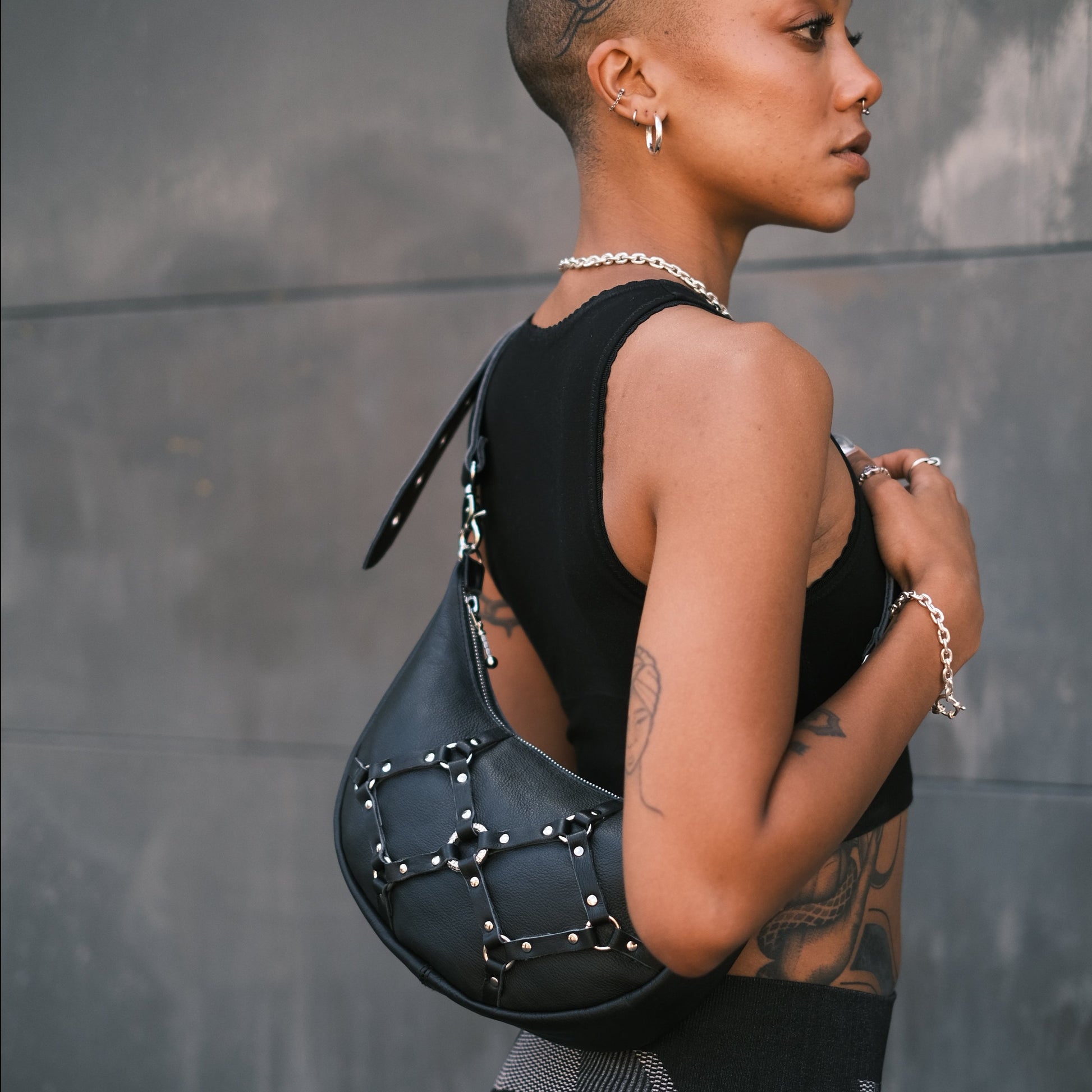 Handmade leather handbag with bold bondage details. Perfect for grunge/alt fashion and festivals like Burning Man. Wear cross-body or on the shoulder with adjustable strap