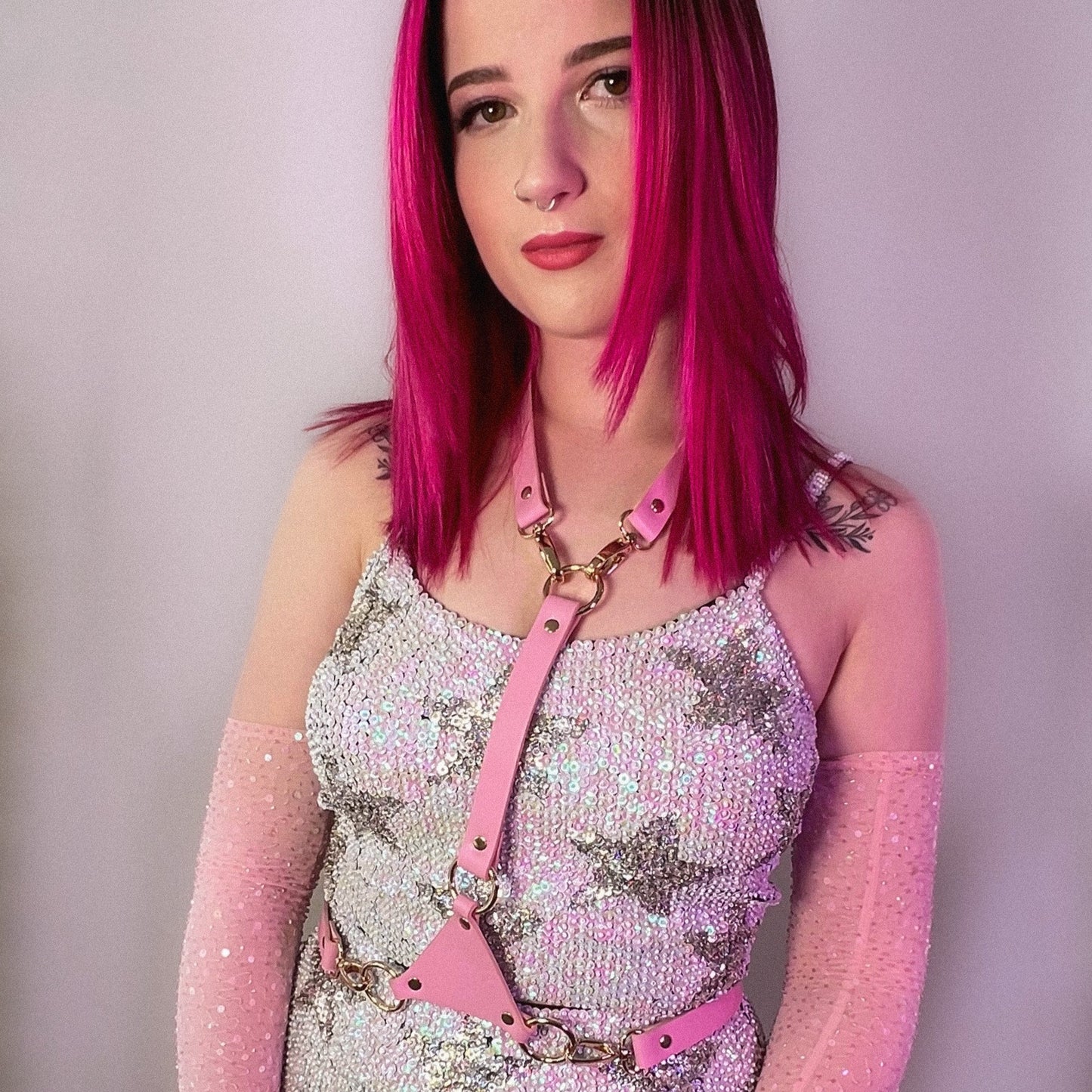festival clothing website with white and silver sequin top for festival outfits, worn with pink harness and gloves.
