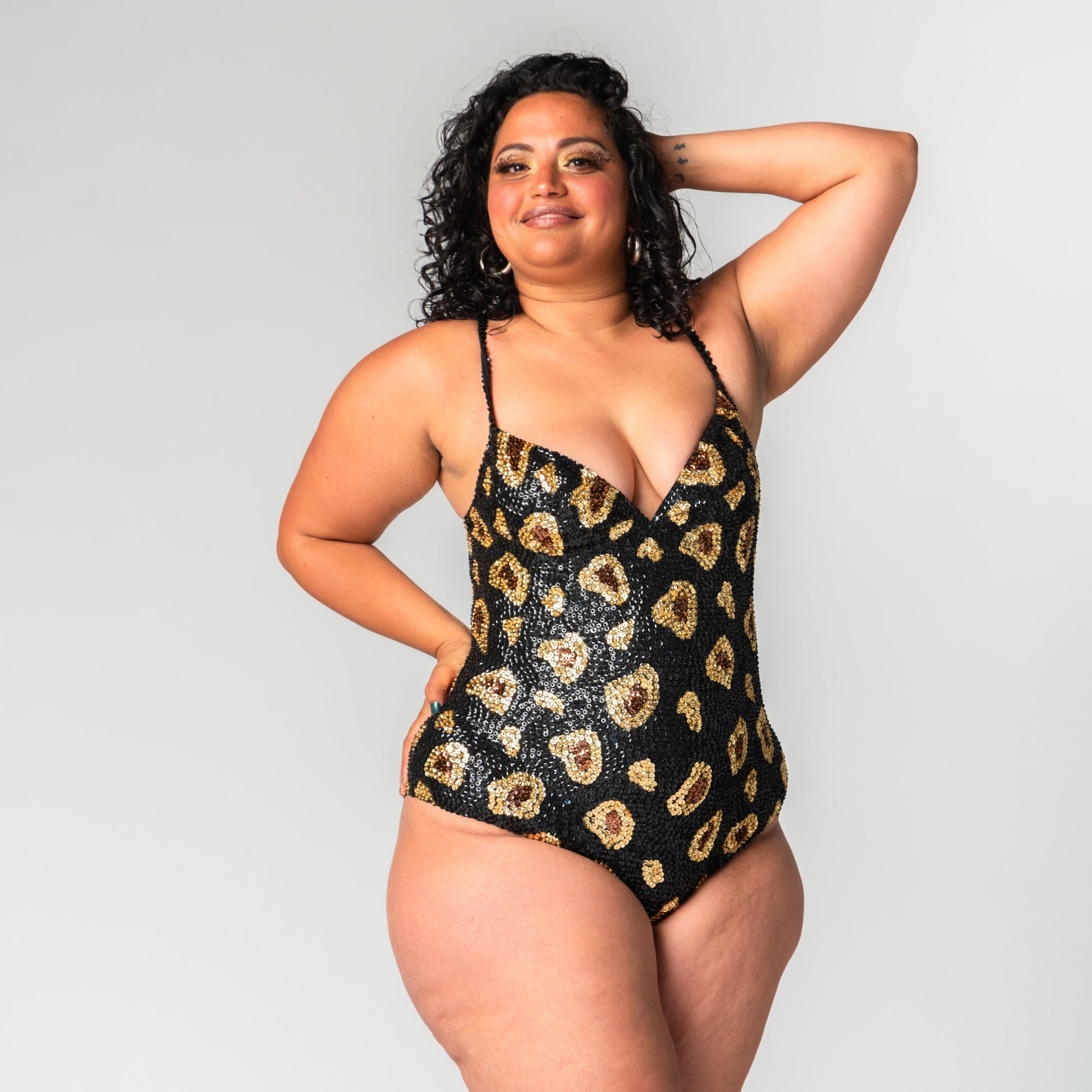 Black leopard bodysuit on size 14 model with black, gold and brown sequins for festival outfits, front view.