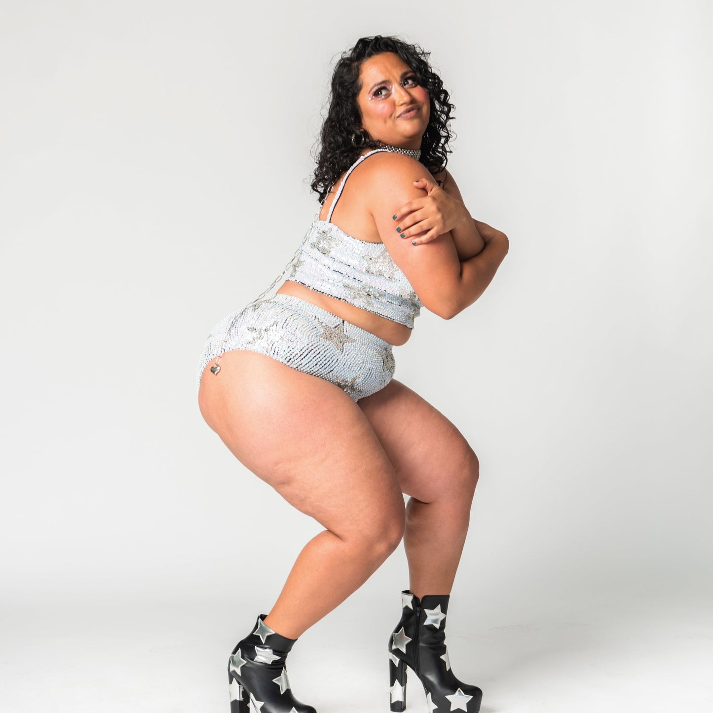 Handmade white and silver sequin high waist festival shorts with star design in plus size. Perfect for festival outfits, bridal party looks, hen do outfits, and Henchella. Chic, sparkly hens hot pants for standout festival fashion.