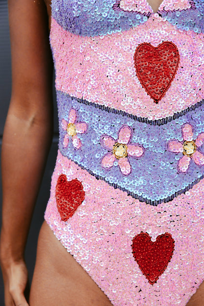 Handmade bodysuit featuring vibrant pink and purple with floral sequins and red hearts. Ideal for festivals and Taylor Swift Eras Tour outfit ideas, offering a bold and unique look.