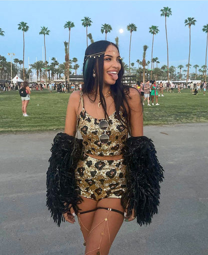 Festival girl living it up at coachella valley music festival, palm trees, palm springs, festival outfit, rave wear fashion, festival girl, expression, gold sequins, golden girl, booty shorts, hot pants, crop top, festival look, festival makeup.