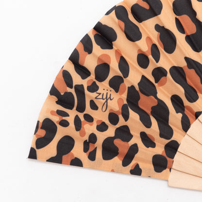 close up of our leopard print design festival hand fan with wooden frame and cotton material fan. 