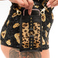designer crossbody phone bag made from genuine leather and featuring adjustable and removable shoulder strap. worn with leopard print hot pants for festival outfit 