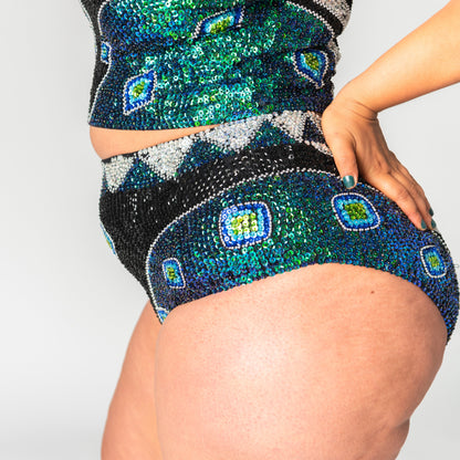 close up of green, black and silver sequin high waist festival shorts for festival outfits on plus size model. 