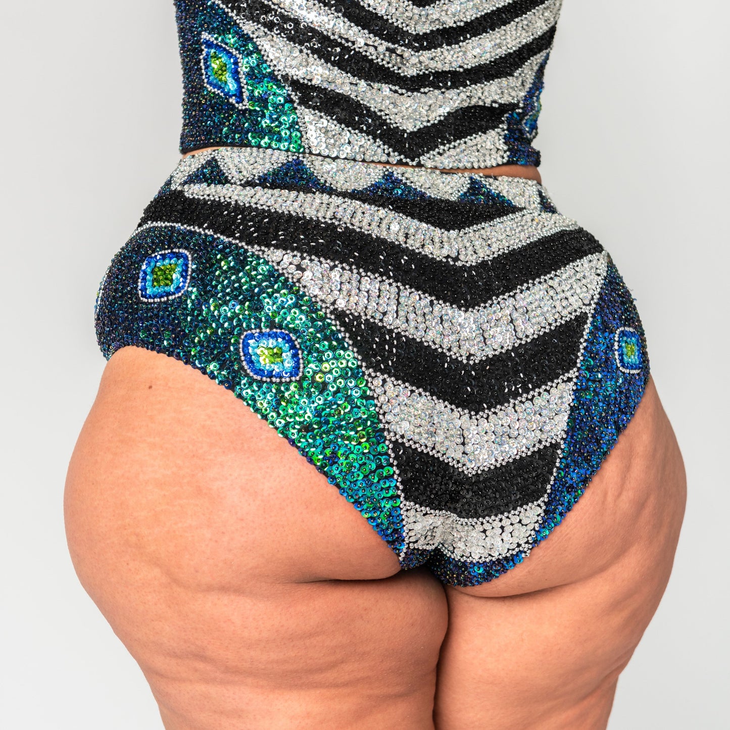 back of green, black and silver festival hot pants for burning man outfits on plus size model. 