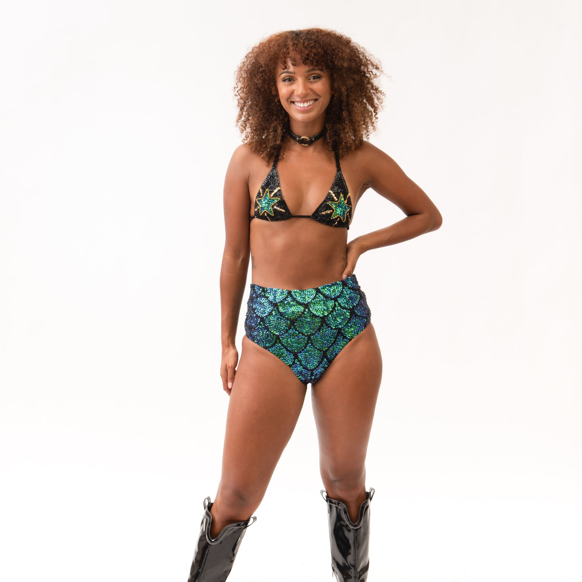 festival outfit matching set with sequin triangle top and hot pants bottoms in mermaid green design, worn with cowboy boots and accessories for rave fashion 