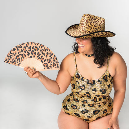 leopard print festival outfit with matching leopard hat, hand fan, hot pants and crop top.