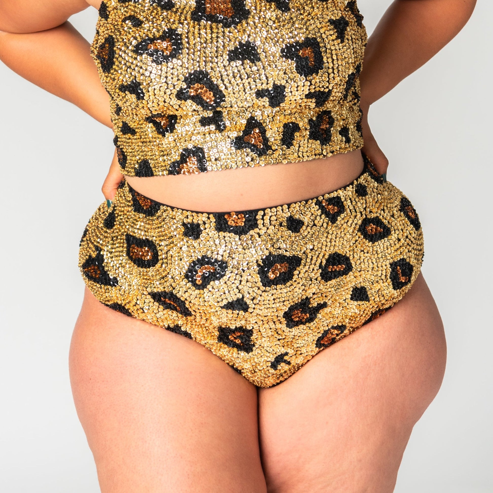 close up of high waist sequin festival shorts on plus size model in gold leopard print design. 