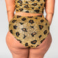 back view of high waist festival hot pants in gold leopard print design on plus size model.