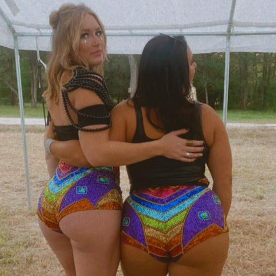Rainbow bottoms on plus size model for festival high waist hot pants for festival outfit or gay pride fashion with rainbow design on bottom.